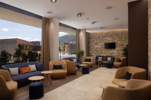 a lobby with couches and chairs and a tv at Hilton Garden Inn Davos in Davos