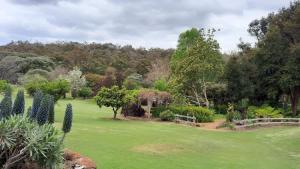 a garden with a green lawn and trees at Cockatoo Lodge - Winery Retreat at Rivendell Estate in Yallingup Siding