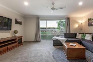 a living room with a couch and a tv at Cockatoo Lodge - Winery Retreat at Rivendell Estate in Yallingup Siding