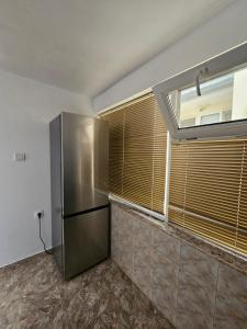 a kitchen with a stainless steel refrigerator and a window at Studio Garden City Center Pomorie in Pomorie