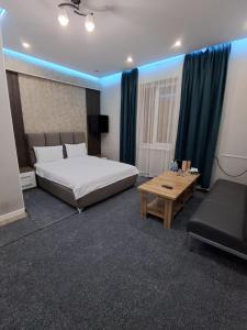 a bedroom with a large bed and a table at Comfort Hotel in Osh +24 photos