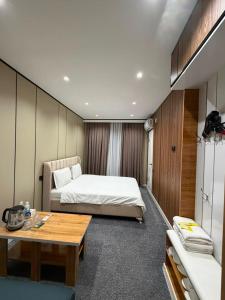 a bedroom with a bed and a desk and a table at Comfort Hotel in Osh
