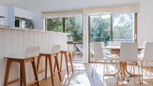 a kitchen with white chairs and a white table at Blissful Escape in Portsea