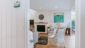 a living room with two chairs and a fireplace at Blissful Escape in Portsea