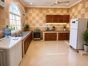 a kitchen with a white refrigerator and a sink at Al Shorooq Residential Complex مجمع الشروق السكني in Salalah +38 photos