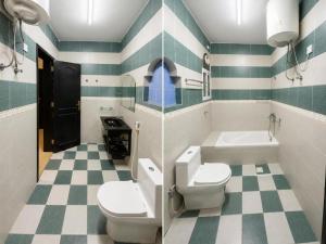 a bathroom with two toilets and a sink and a tub at Al Shorooq Residential Complex مجمع الشروق السكني in Salalah