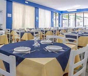 a dining room with tables and chairs with plates on them at Hotel ITALY in Misano Adriatico +25 photos