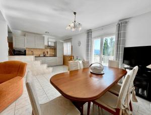 a living room with a wooden table and a kitchen at Villa Joković in Lumbarda