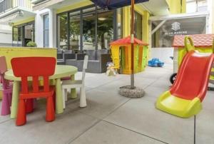 a room with colorful chairs and a table and an umbrella at Hotel ITALY in Misano Adriatico