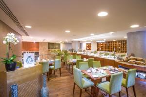 un restaurante con mesas y sillas y un bar en The Avenue Hotel, en Doha