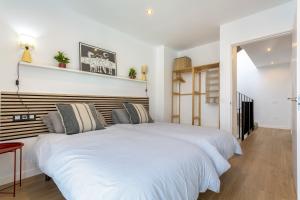 a bedroom with a white bed with a wooden headboard at Salitre y lava in Corralejo +27 photos