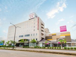 a white building with a sign on top of it at Tsubamesanjo Washington Hotel in Sanjo