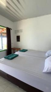 two large white beds in a room with a window at AAL Homestay Syariah in Sabang
