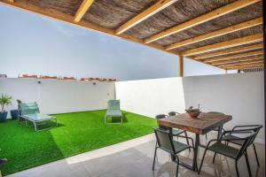a room with a table and chairs and grass at Salitre y lava in Corralejo