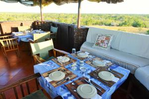 a table with plates and dishes on a couch at Babs' Camp, A Tent with a View Safaris in Saadani