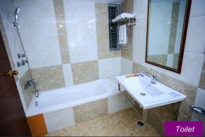 a bathroom with a tub and a sink and a bath tub at Royal Beach Resort in Cox's Bazar