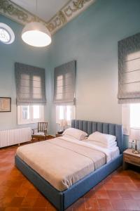 a large bed in a bedroom with blue walls and windows at Beit Toureef - SARAYA HALA 'PALATIAL' in Beirut
