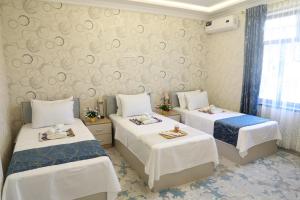 a bedroom with two beds and a wall with swirls at OSMAN villa in Samarkand
