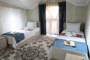 a bedroom with two beds and a window at OSMAN villa in Samarkand +32 photos