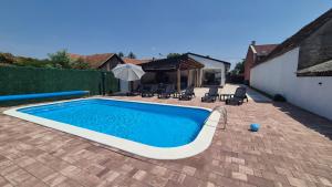 a swimming pool in a yard with chairs and an umbrella at Kuća za odmor Terra Marta in Đakovo