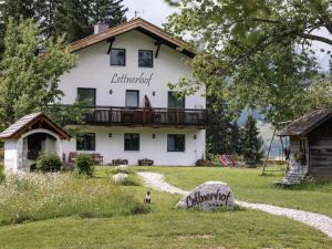 a large white house with a balcony at Bnb Lettnerhof Balcony Family Suite in Monguelfo