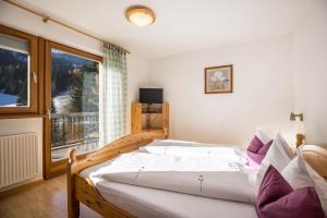 a bedroom with a bed and a large window at Bnb Lettnerhof Balcony Family Suite in Monguelfo
