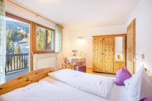 a bedroom with a bed and a large window at Lettnerhof Bnb Family Suite 4 in Monguelfo