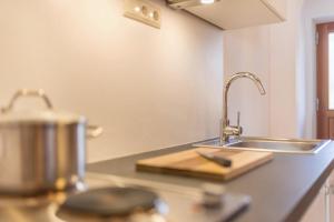 a kitchen counter with a sink and a cutting board at Lettnerhof Bnb Family Suite 4 in Monguelfo +17 photos