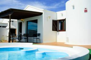 een zwembad voor een huis bij Villa La Concha in Playa Honda