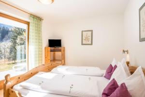 a bedroom with two beds and a window at Lettnerhof bnb Family Suite 3 in Monguelfo
