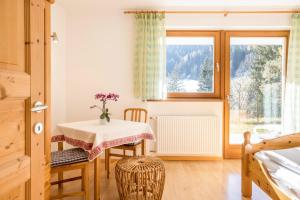 a dining room with a table and a window at Lettnerhof bnb Family Suite 3 in Monguelfo