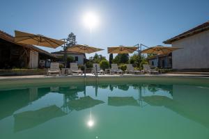 a swimming pool with chairs and umbrellas at Вила Рай in Elena