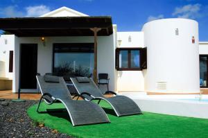 een groep banken op het gras voor een huis bij Villa La Concha in Playa Honda
