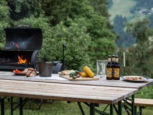 a picnic table with food and bottles of beer and a grill at Lettnerhof bnb Family Suite 2 in Monguelfo