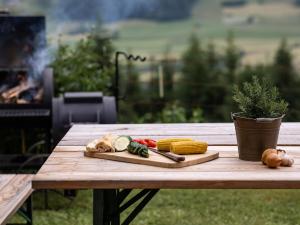 a cutting board with vegetables on a wooden table at Bnb Lettnerhof Terrace Family Suite in Monguelfo