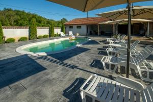 a swimming pool with chairs and an umbrella at Вила Рай in Elena