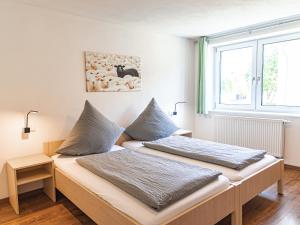 two beds in a room with a window at Ferienhof Häckler in Ochsenhausen