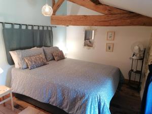 a bedroom with a bed with a blue comforter at Maison Les Fleuries in Saint-Quentin-de-Chalais +17 photos