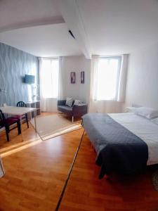 a bedroom with two beds and a table and a couch at Les Chenes Chambres D'hote in Châtel-Guyon +5 photos