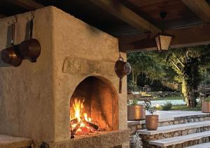 a stone pizza oven with a fire in it at Villa Olmeto in Lupoglav