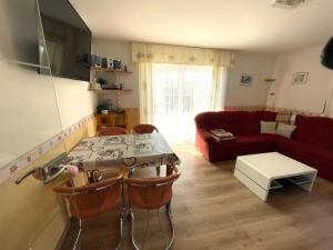 a living room with a table and a red couch at 10 Ferienwohnung Anders Fewo 1 in Burg auf Fehmarn
