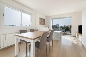 a white dining room with a table and chairs at Apartamento las palmeras 2 Planta 3 in Cala Millor