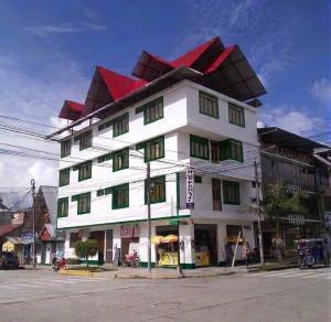a large white building with a red roof at Hospedaje Vista Alegre in Oxapampa
