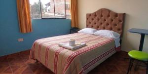 a bedroom with a bed with a tray with a candle on it at Hospedaje Vista Alegre in Oxapampa