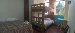 a bedroom with a bunk bed and a bed at Hospedaje Vista Alegre in Oxapampa
