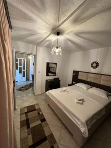 a bedroom with a large white bed and a chandelier at Apartments Tati in Ulcinj +137 photos
