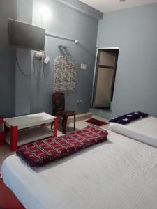 a room with two beds and a table and a mirror at Subhalaxmi Hotel and Lodge in Bahāsi