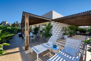 a patio with chairs and tables on a roof at The 12th City Hotel in Rhodes Town