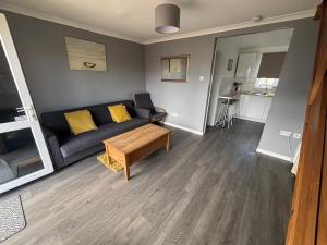 a living room with a couch and a table at 124, Three bed two storey chalet on Bermuda holiday park, Hemsby - Sleeps 7, bed linen and towels included with onsite entertainment and further entertainment close by - includes balcony in Great Yarmouth +16 photos