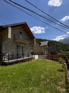 a house with a fence in front of a yard at Villa Malesia in Peje